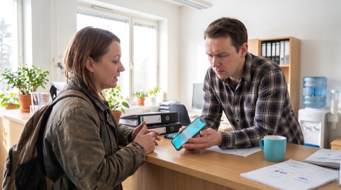 A customer and a staff member working patiently through a language barrier at a counter